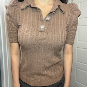 Polo shirt with ruffled sleeves and flower brooch
